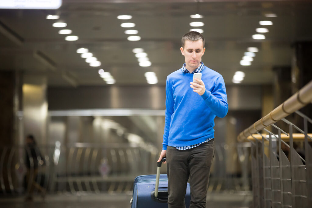 Viajante do viajante usando o telefone no aeroporto